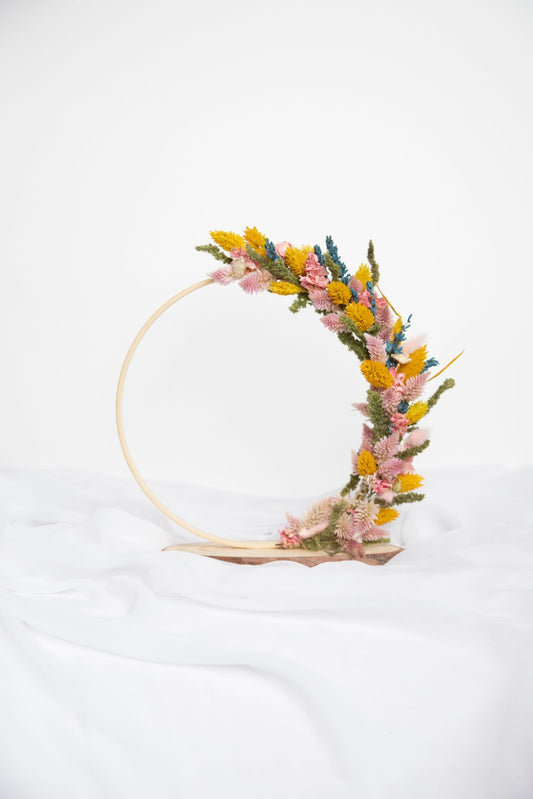 Corona floral semicircular en aro de madera